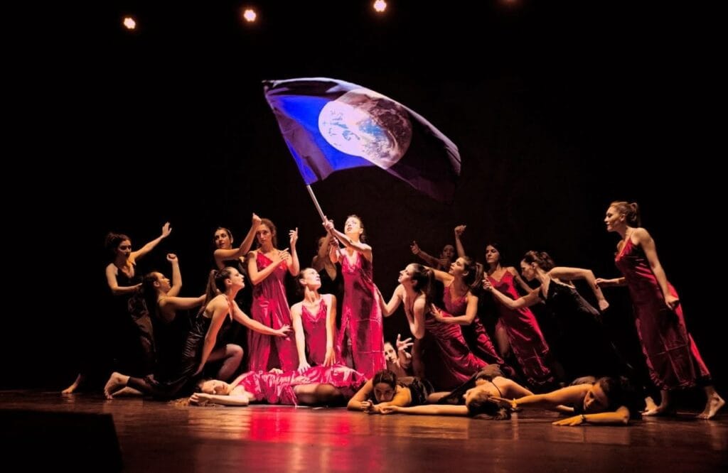 Three confident dancers performing against a purple gradient backdrop, showcasing dynamic movement and individual style in artistic lighting
